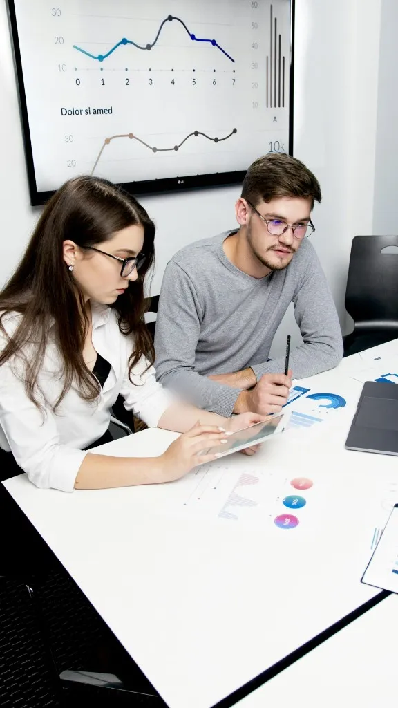 Colleagues reviewing data and delivery plans together at a desk - mobiloitte singapore